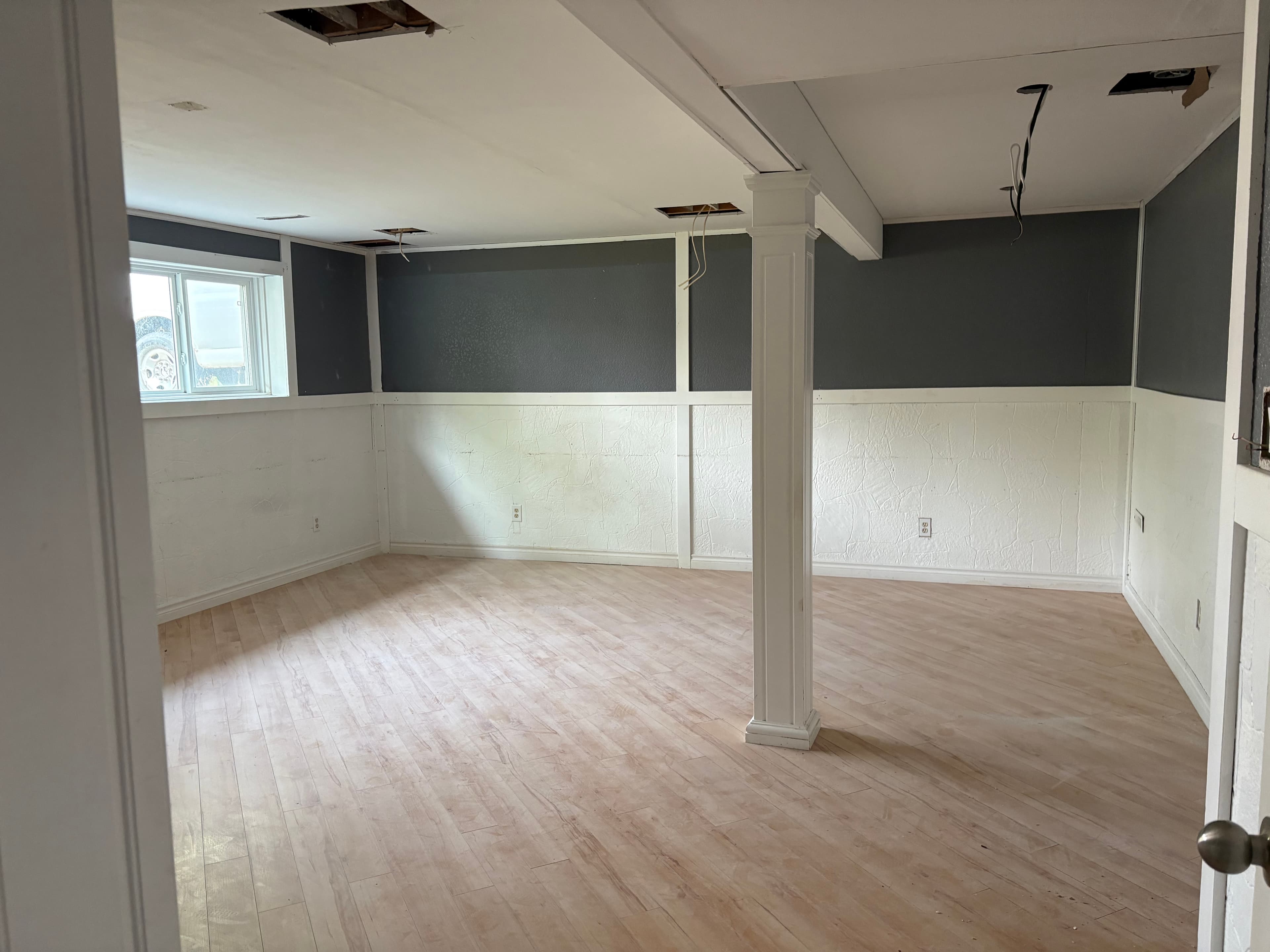 Residential interior during renovation: wainscot, charcoal upper walls, and ceiling lighting rough-in before finish